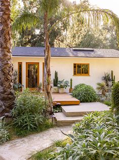 a white house surrounded by trees and plants