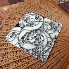 an intricately designed paper piece on top of a wooden table