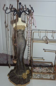 there is a mannequin and jewelry on display in the room with it's clothes rack