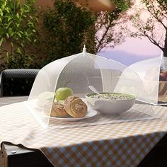 a bowl of cereal and an apple on a table with a clear cover over it