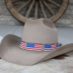 Celebrate your patriotism with this handcrafted beaded hat band showcasing a vibrant American flag design. Adjustable leather ties ensure a comfortable fit on any hat size. At 21 1/2" in length and 1 1/8" in width, this band adds a touch of American spirit to your look. Wear your love for the USA proudly wherever you go!    Adjustable with Leather ties  Length: 21 1/2 (not including ties)  Width: 1 1/8" Adjustable Southern Style Hat Bands For Country Events, Southern Style Adjustable Hat Bands For Ranch, Country Style Beaded Hat Bands For Country Events, Adjustable Patriotic Hats For Country Events, Patriotic Adjustable Hats For Country Events, American Style Adjustable Hat With Flat Brim, American Style Adjustable Flat Brim Hat, Adjustable Americana Hats For Country Events, Adjustable Patriotic Hats