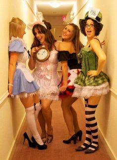 three women dressed in costumes are posing for the camera