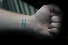 a person's arm with a small blue tattoo on the left side of their wrist