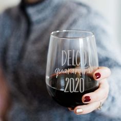 a woman holding a wine glass with the words, delectable women are 2020 written on it