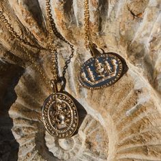 two necklaces that are sitting on a rock