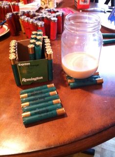 there are many batteries on the table next to a jar of milk and some pens