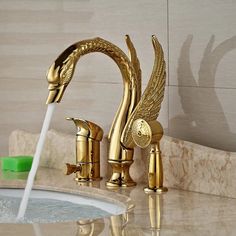 a golden faucet with an angel design on it and water running from the faucet