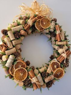 a wreath made out of wine corks, orange slices and pine cones is hung on the wall