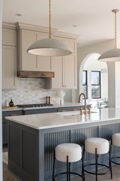 a kitchen island with four stools next to it