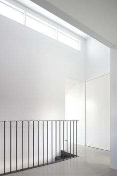 an empty room with white walls and black railings