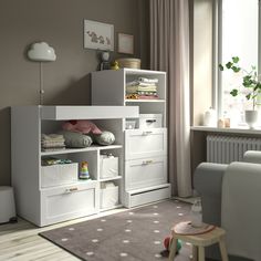 a baby's room with white furniture and decor