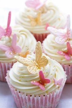 cupcakes with white frosting and pink butterflies on the top one is decorated