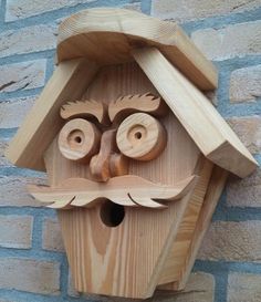 a wooden birdhouse with a face made out of wood