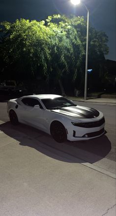 a white sports car parked on the street at night