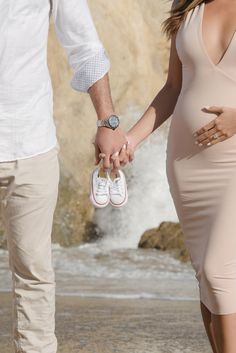 a pregnant woman holding the hand of a man