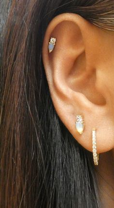 a close up of a person's ear with two different types of piercings