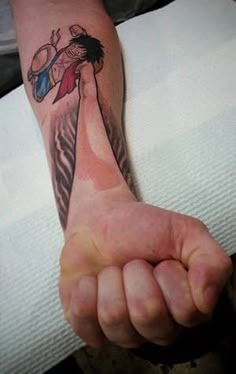 a person with a tattoo on their arm holding up a hand and pointing at the camera