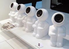 there are four white statues with speakers on them