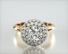 an engagement ring with a round diamond center surrounded by small white and yellow gold accents