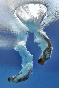 an underwater view of a man swimming in the water