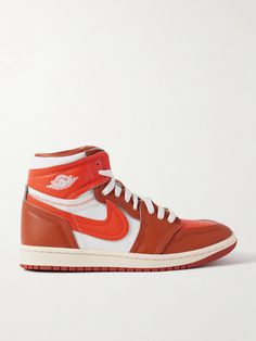 Nike's 'Method of Make' line takes iconic sneakers and elevates them with luxurious materials and details. Part of the series, this 'Air Jordan 1' pair is made from layered panels of leather and twill in a vibrant orange colorway. Show off the high-top profile with shorts or cropped pants. Luxury Nike Sneakers For Sports, Nike Luxury Leather Sneakers, Luxury Nike Custom Sneakers For Streetwear, Designer High-top Custom Sneakers With Translucent Outsole, Nike Leather High-top Sneakers With Abzorb Midsole, Luxury High-top Custom Sneakers With Translucent Outsole, Custom Orange Leather Sneakers With Translucent Outsole, Luxury Custom High-top Sneakers With Translucent Outsole, Leather High-top Sneakers For Sports With Branded Heel Counter