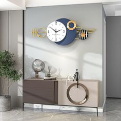 a clock mounted to the side of a wall next to a plant in a vase