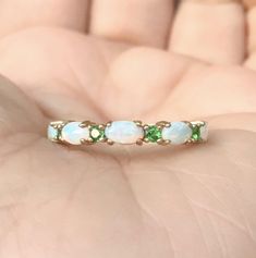 Opal and Emerald Half Eternity Band Ring. MaterialSolid Gold (14K/18K) or Platinum 950 FinishingHigh Polished/Shiny PlatingRhodium/Platinum Family (Only if white gold selected) FitStandard Width3.2 mm Height3 mm SettingProng Stone #1Natural Opal ShapeOval Size3mm x 5mm Quantity5 Opals ColorWhite with Fire-like hues of Orange, Yellow and Red Stone #2Natural Emerald QualityAAA CutRound, Diamond Cut Size2mm Quantity4 Emeralds Click below to add laser engraving. https://www.etsy.com/listing/63107091 Oval 14k Gold Eternity Band, Oval Multi-stone Emerald Ring In White Gold, Fine Jewelry Oval Stackable Rings With Prong Setting, Oval Opal Ring For Anniversary, Green Gemstone Eternity Band For Wedding, Oval Opal Halo Ring In 14k Gold, Formal Oval Gemstone Stackable Rings, Oval Gemstone Stackable Rings For Formal Occasions, Fine Jewelry Oval Stackable Rings For Anniversary