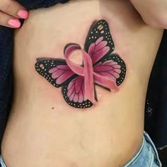 a woman's stomach with a pink ribbon and butterfly tattoo