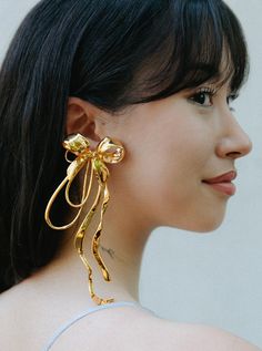 Inspired by the iconic form of its namesake, the Asymmetric Bow Earrings are a modern take on the classic shape and reimagined in the form of a stunningly statement mismatched pair of earrings - including one Bow XL Earring and one Mini Bow Stud. Immortalised as a handcrafted piece and plated in a choice of 24k Gold or Silver Rhodium, MISHO reinvents the ribbon with sculptural twist. Modern Earrings With Plating For Evening, Modern Evening Earrings With Plating, Modern Gold Plated Earrings For Evening, Modern Gold Plated Evening Earrings, Modern Clip-on Earrings For Party, Contemporary Single Earring For Formal Occasions, Modern Gold Plated Earrings For Party, Modern Clip-on Party Earrings, Modern Party Earrings With Plating