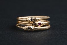 The perfect solid gold dainty ouroboros ring, now with a twist. A tiny gemstone set on snake's head. Choose your favourite among three options. Pink ruby, Dark blue sapphire or black diamond. Stack with your other rings or wear alone for a minimal look. The listing is for ONE (1) ouroboros ring. The ring has been made in wax and then casted in 14k solid gold. -DETAILS- *14k solid gold *Ring's band measures about 1.5 mm in width *Can be sized in specific sizes. Please choose yours during checkout Snake-shaped Engraved Rings For Gifts, Snake Shaped Engraved Rings For Gifts, Engraved Snake-shaped Rings For Gifts, Engraved Snake Shape Ring For Gift, Antique Snake-shaped Yellow Gold Jewelry, Antique 14k Gold Snake Ring Gift, 14k Gold Snake Jewelry For Anniversary, Ouroboros Jewelry, Ouroboros Ring