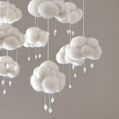 a group of white clouds hanging from the ceiling with crystal drops dangling from each cloud