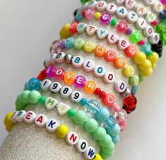 the bracelets are all different colors and have words written on each beaded strand