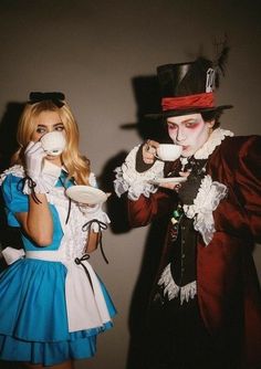 two people dressed up as alice and the mad hatter, one holding a plate