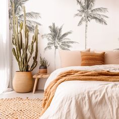 a bedroom with palm trees painted on the wall and a bed in front of it