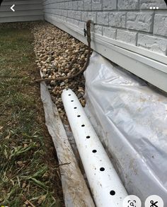 a white pipe laying next to a house