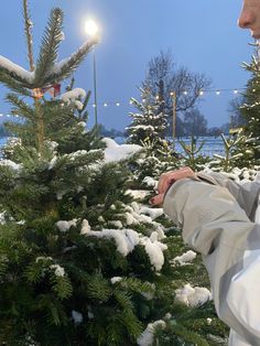 a man standing next to a christmas tree