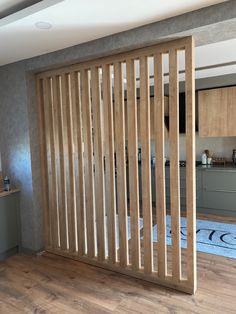 an open wooden door in a kitchen with hardwood flooring and walls painted light brown