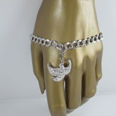 This vintage bracelet by Kenneth J Lane is charming in more ways than one... Done in silver tone with a double link design the bracelet features a single Dove charm at its center that boasts clear rhinestones that twinkle and shine. The bracelet is 7.5 inches from end to end (includes clasp) while the Bird is .75 high and 7/8 inch wide (does NOT include clasp). The charm is marked KJL, China on the back and the bracelet has a KJL, Korea hang tag. Both Dove and bracelet are in excellent condition Silver Metal Charm Bracelet With Chain, Vintage Silver Bracelets With Adjustable Chain, Vintage Silver Charm Bracelet For Wedding, Vintage White Gold Metal Chain Bracelet, Adjustable Silver Charm Bracelet In Costume Jewelry Style, Adjustable Silver Charm Bracelet Costume Jewelry, Silver Costume Jewelry Charm Bracelet, White Gold Metal Chain Bracelet With Charms, White Gold Chain Bracelet With Charms