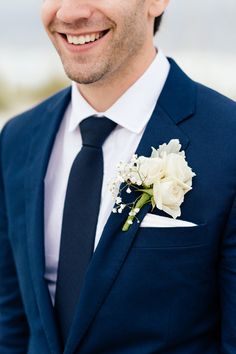 a man wearing a suit and tie with a flower on it's lapel