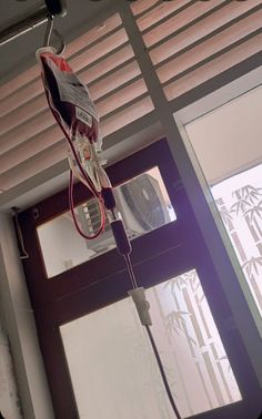 a fan is hanging from the ceiling in front of a window with blinds on it