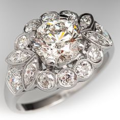 a diamond ring with an intricate design on the center and sides, surrounded by smaller diamonds