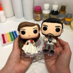 the bride and groom are holding their wedding cake toppers