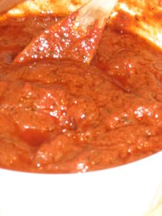 a white bowl filled with red sauce on top of a table