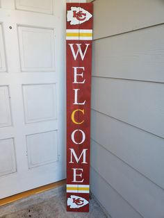 a wooden sign that says welcome to the team and is painted red, yellow and white