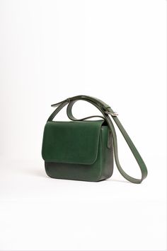 Natural-grained leather fanny pack lined with cotton fabric a metal zipper closure, and an adjustable strap allowing it to be worn over the shoulder as a crossbody bag, or around the waist. It has two zippered pockets, one on the front and one on the back. Modern Flap Shoulder Bag With Leather Lining, Everyday Leather-lined Flap Shoulder Bag, Modern Shoulder Bag With Leather Lining And Flap, Everyday Flap Shoulder Bag With Leather Lining, Modern Everyday Flap Bag With Leather Handles, Classic Crossbody Flap Bag With Leather Handles, Travel Satchel With Removable Pouch And Double Flap, Green Saddle Bag With Removable Pouch, Green Saddle Bag With Removable Pouch For Everyday