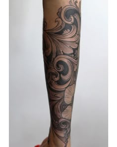 a woman's leg with tattoos on it and her foot in the air,