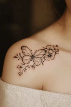 a woman's shoulder with flowers and butterflies tattoo on her left side breast area