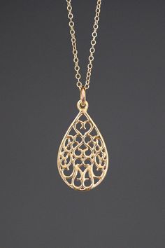 "A beautifully detailed 14k gold filigree teardrop charm simply dangles from a fine 14k gold filled chain. The chain is finished with a spring ring clasp. It is adjustable and can be worn close to the neck at 16\" or a little longer at 18\". This lightweight go-with-everything necklace completes any outfit for daytime or evening. Gold filigree charm: 12.5x23mm Total length of charm: 1\" Gold chain: 1mm Matching earrings are available... www.etsy.com/listing/760560566/gold-filigree-earrings As th Wedding Filigree Teardrop Necklace, Delicate Gold Pear-shaped Necklace, Delicate Pear-shaped Gold Necklace, Teardrop Pendant Necklace With Intricate Design For Gift, Gold Filigree Teardrop Pendant Jewelry, Filigree Drop Jewelry As Gift, Filigree Drop Jewelry For Gifts, Intricate Teardrop Pendant Necklace As Gift, Teardrop Jewelry With Intricate Design For Gifts