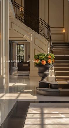 a large vase with flowers sitting on top of a table in front of a staircase