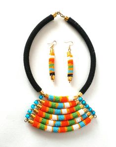 This unique beaded necklace comes with matching earrings. Perfect for both official and casual wear. The necklace is 100% handcrafted using fine beads. The pendant contains 6 colorful strands joined together using solid brass metal findings making it hard to break. The length of the necklace is 18 inches long Pendant: 2.5 inches long Earrings:2.5 inches. S shape clasp is used for closure. **Buy multiple items and pay shipping for 1 item only.The rest ships free. More neckleces here; https://www. Handmade Multicolor Metal Beads, Unique Multicolor Jewelry With Gold Beads, Multicolor Metal Beads Jewelry With Dangling Beads, Multicolor Metal Beaded Necklaces With Large Beads, Multicolor Dangling Beads Metal Jewelry, Multicolor Metal Bead Dangle Jewelry, Multicolor Metal Bead Jewelry With Dangling Beads, Multicolor Metal Beaded Jewelry, Traditional Multicolor Beaded Earrings With Gold Beads